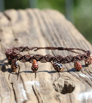 Makramee-Armband als Welle genotet mit kleinen schwarzen Muscheln mit Punkten