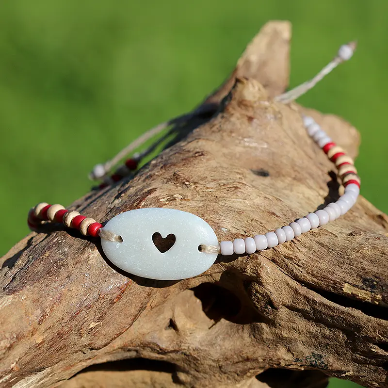 Armband mit Strandstein / Kieselstein mit von Hand gebohrtem Herz und kleinen Glasperlen