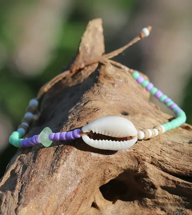 Perlen - Armband in Lila / Mintgrün mit Cowrie - Muschel. Individueller Schmuck aus Strandgut.