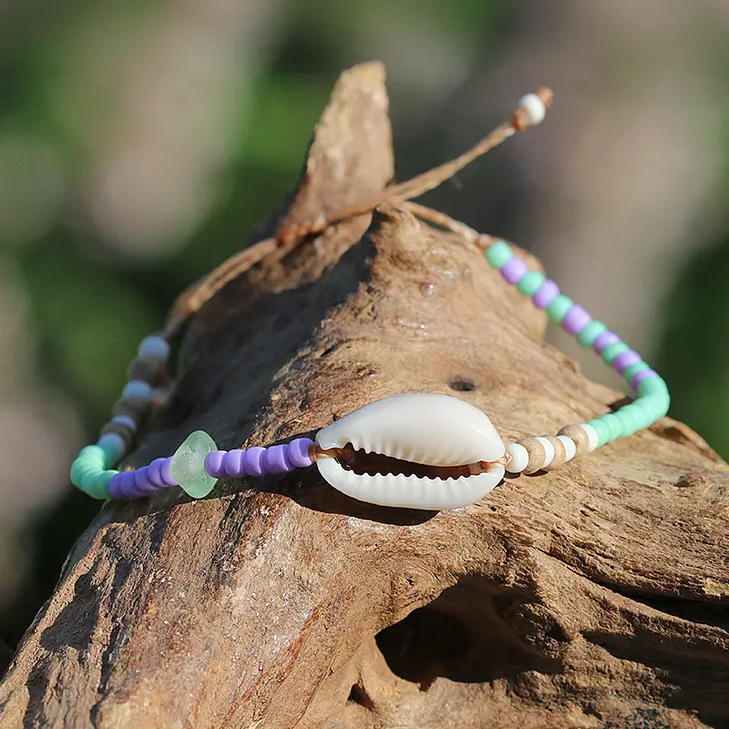 Perlen - Armband in Lila / Mintgrün mit Cowrie - Muschel. Individueller Schmuck aus Strandgut.